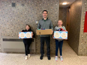 Dr. Jake and 2 students from West Iron School with the donation from our hat/mitten drive.